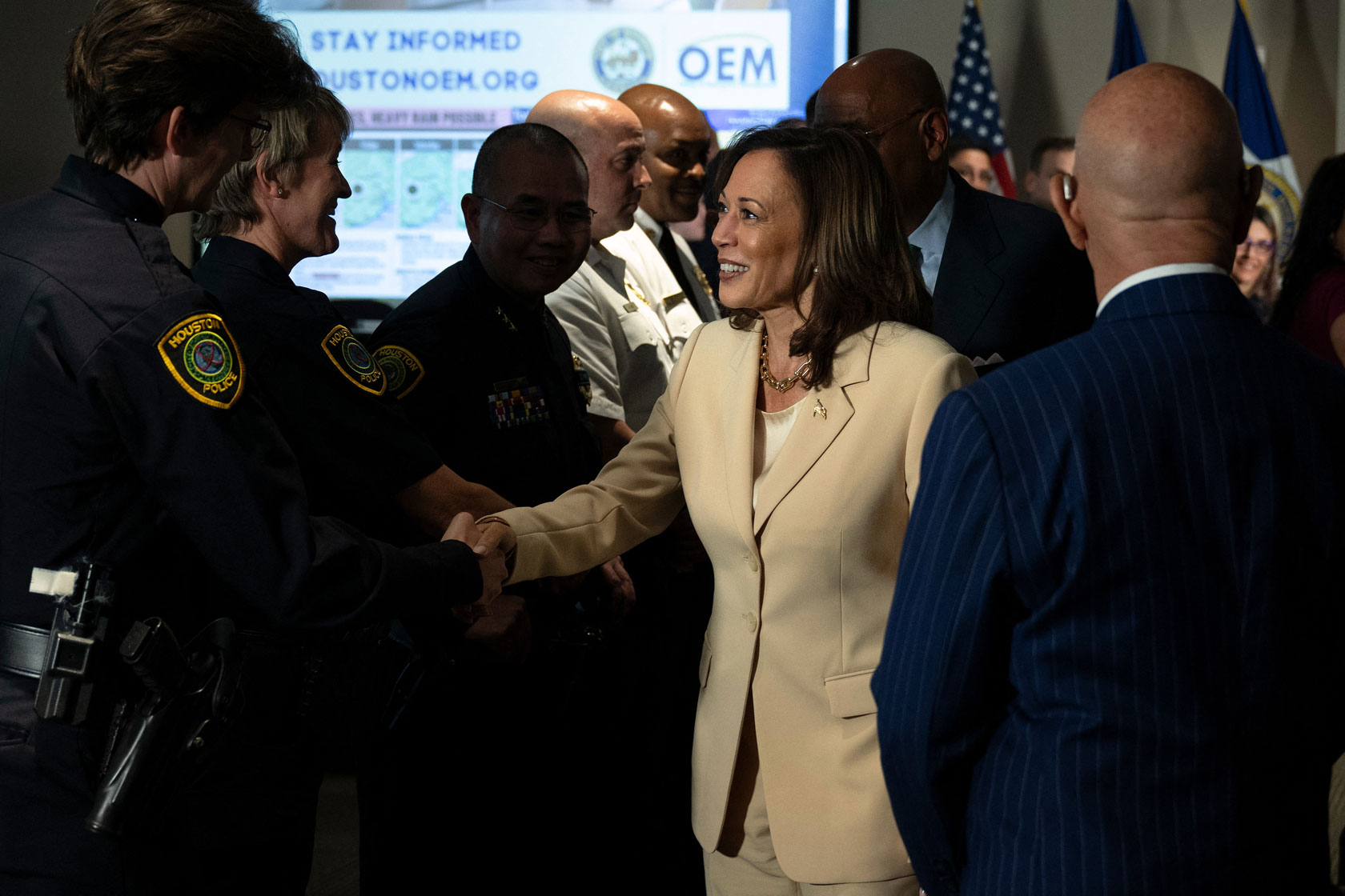 Vice President Kamala Harris shakes hands with a Houston police officer. Other first responders are behind Harris.