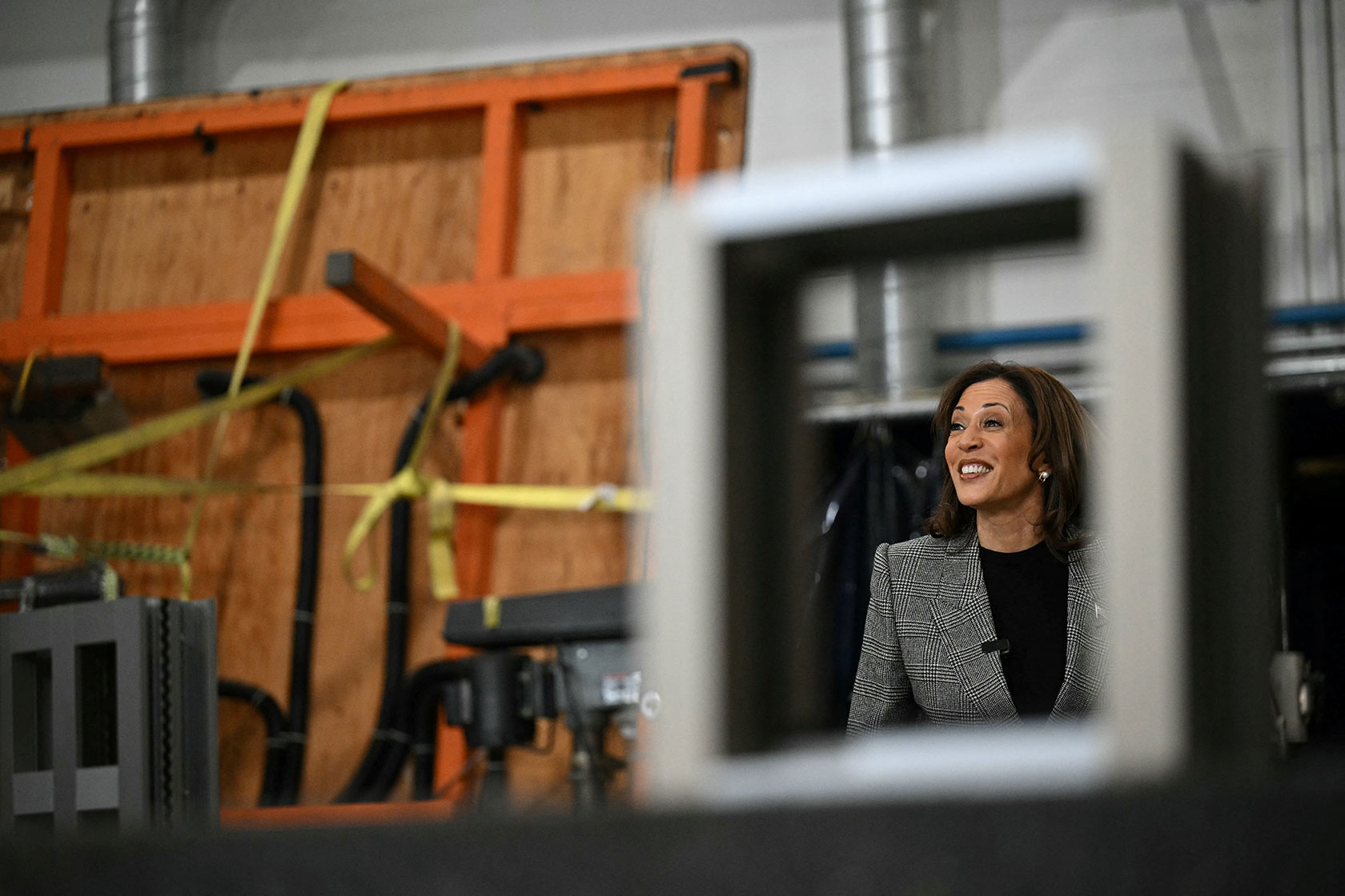 Photo shows Kamala Harris smiling as she stands and looks around a training site